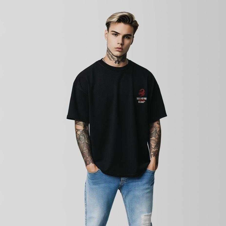 Man wearing a black oversized t-shirt with a logo of hellmode and blue jeans on a plain back by coldrelics
